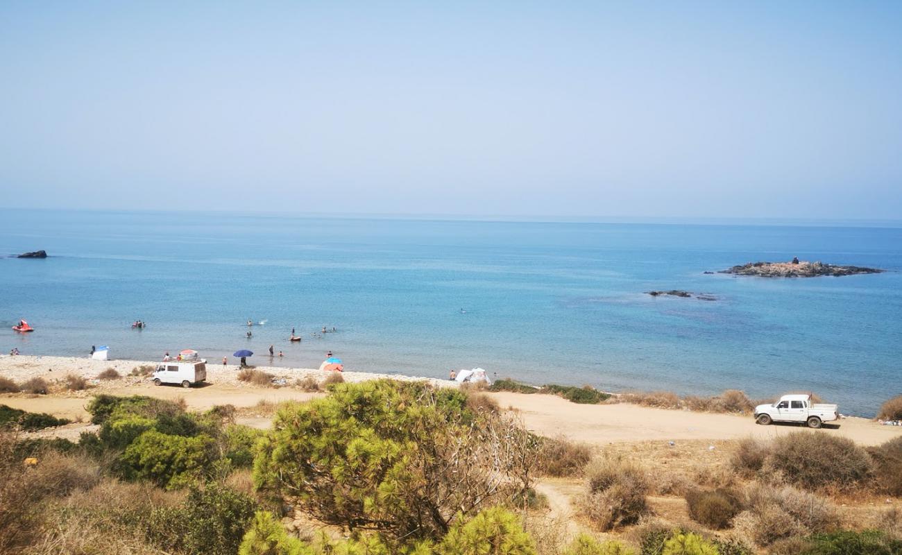 Photo de Adjroud beach avec sable brillant et rochers de surface