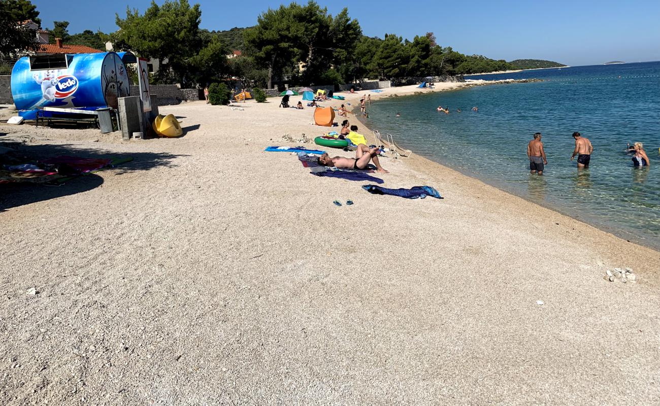 Photo de Varos beach avec sable beige & galets de surface