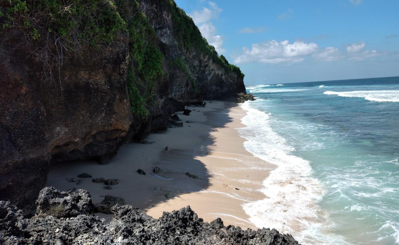 Photo de Alila Uluwatu Beach avec sable brillant et rochers de surface