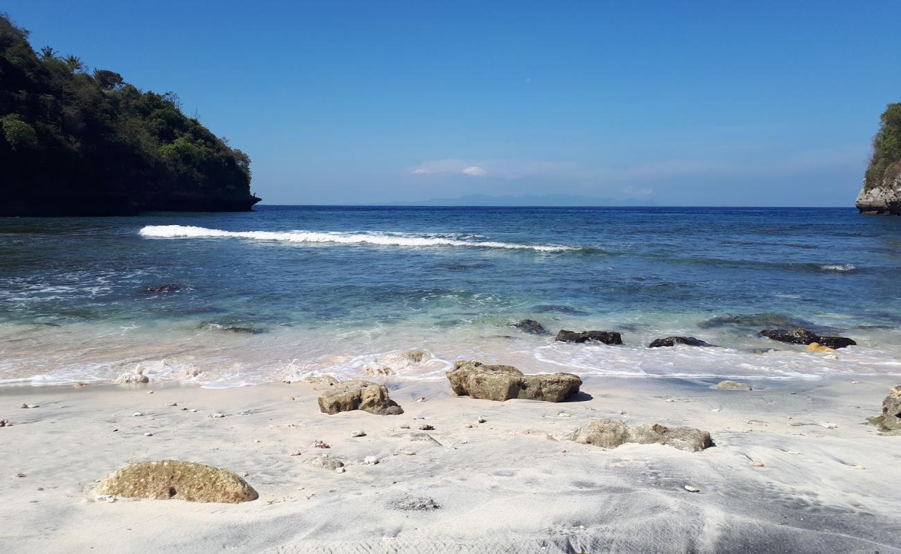 Photo de Sebele beach avec sable gris avec roches de surface