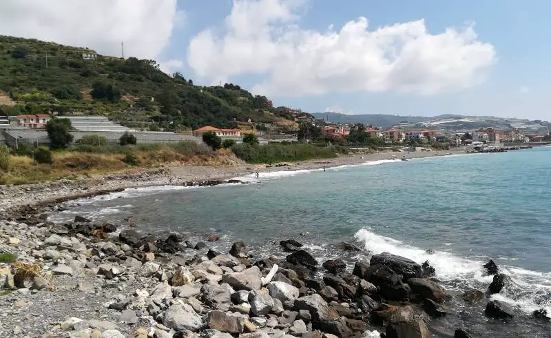 Photo de Via Bartumelin beach avec sable gris avec roches de surface