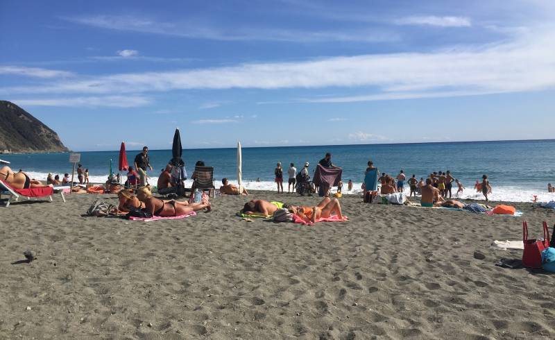 Photo de Riva Ponente avec sable noir avec caillou de surface