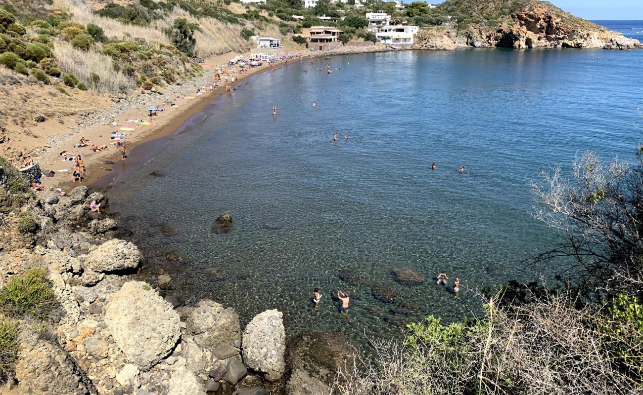 Photo de Cala Zimmari avec sable brun de surface