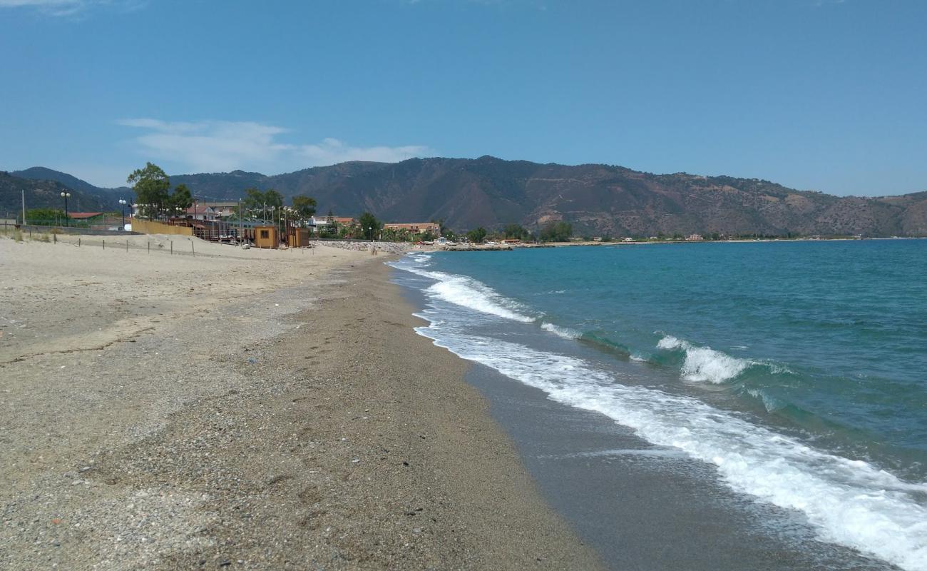 Photo de Spiaggia Falcone avec sable beige & galets de surface