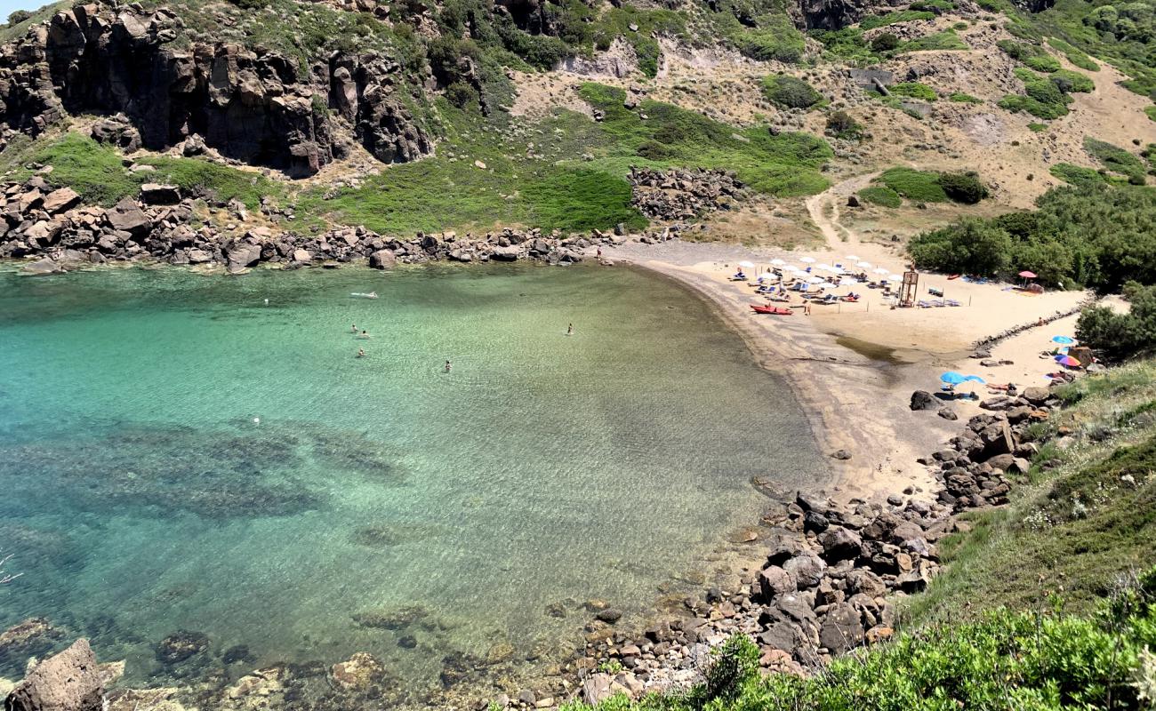 Photo de Cala Ostina avec sable brun de surface