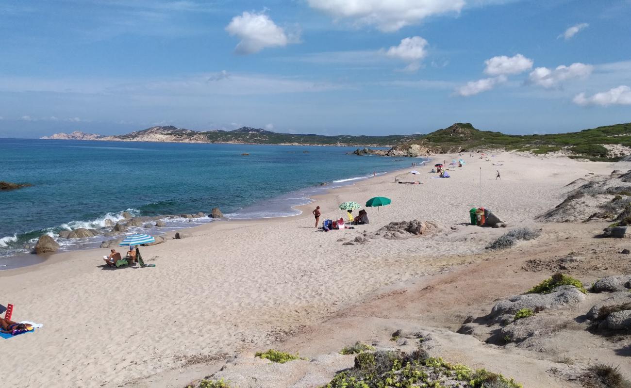 Photo de Cala Pischina avec sable brun de surface
