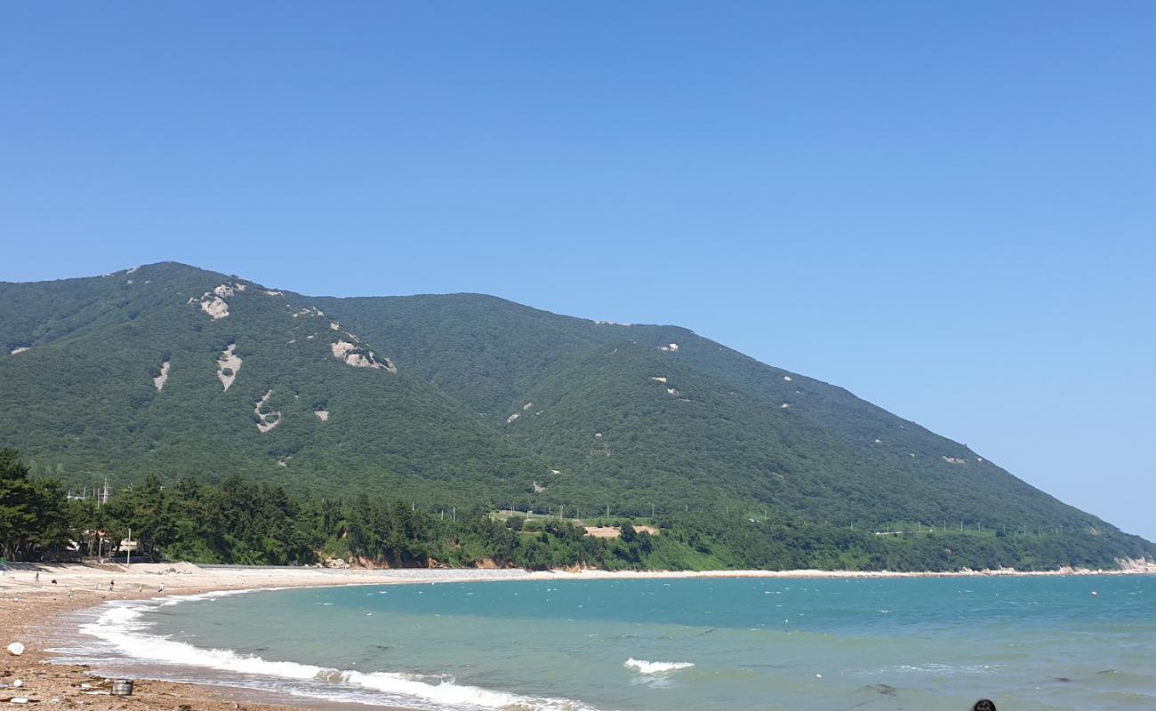 Photo de Geumjang Beach avec sable gris avec roches de surface