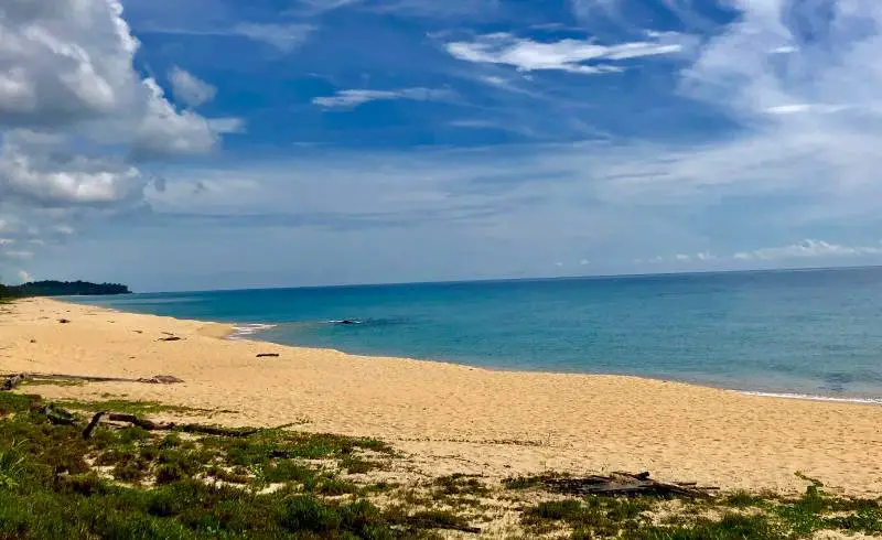 Photo de Pantai Teluk Bidara avec sable lumineux de surface