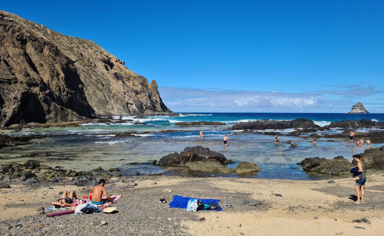 Photo de Porto das Salemas avec sable gris & rochers de surface