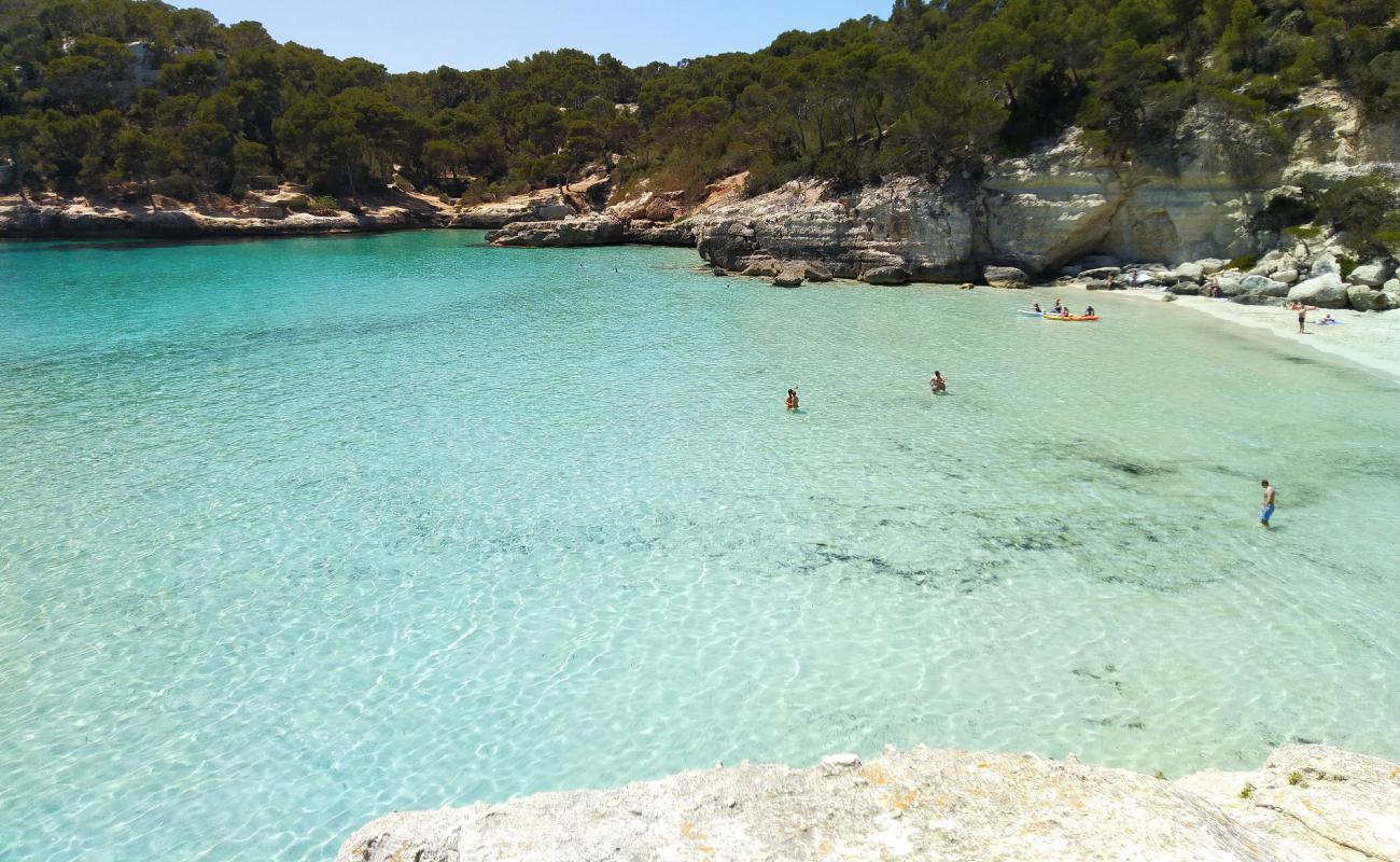 Photo de Cala Mitjana avec sable fin et lumineux de surface