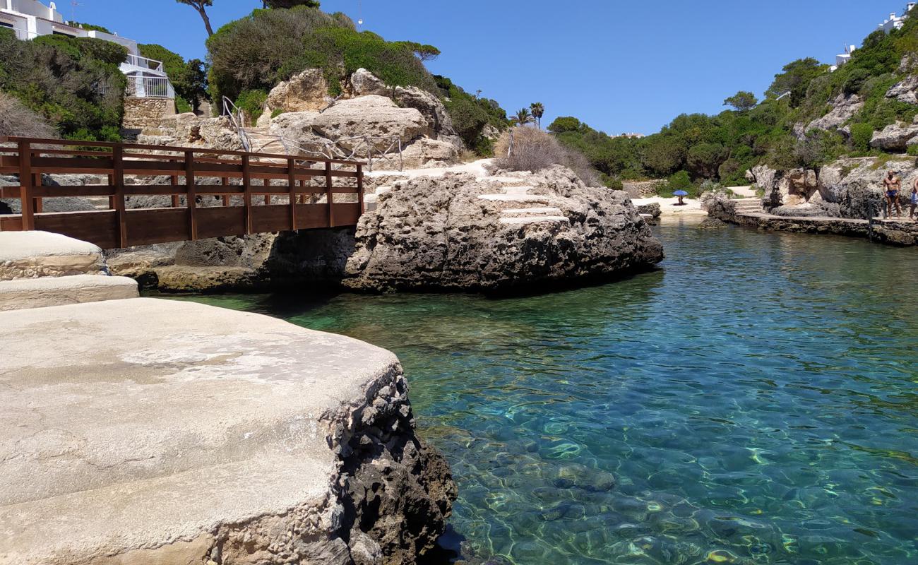 Photo de Cala en Forcat avec sable gris avec roches de surface