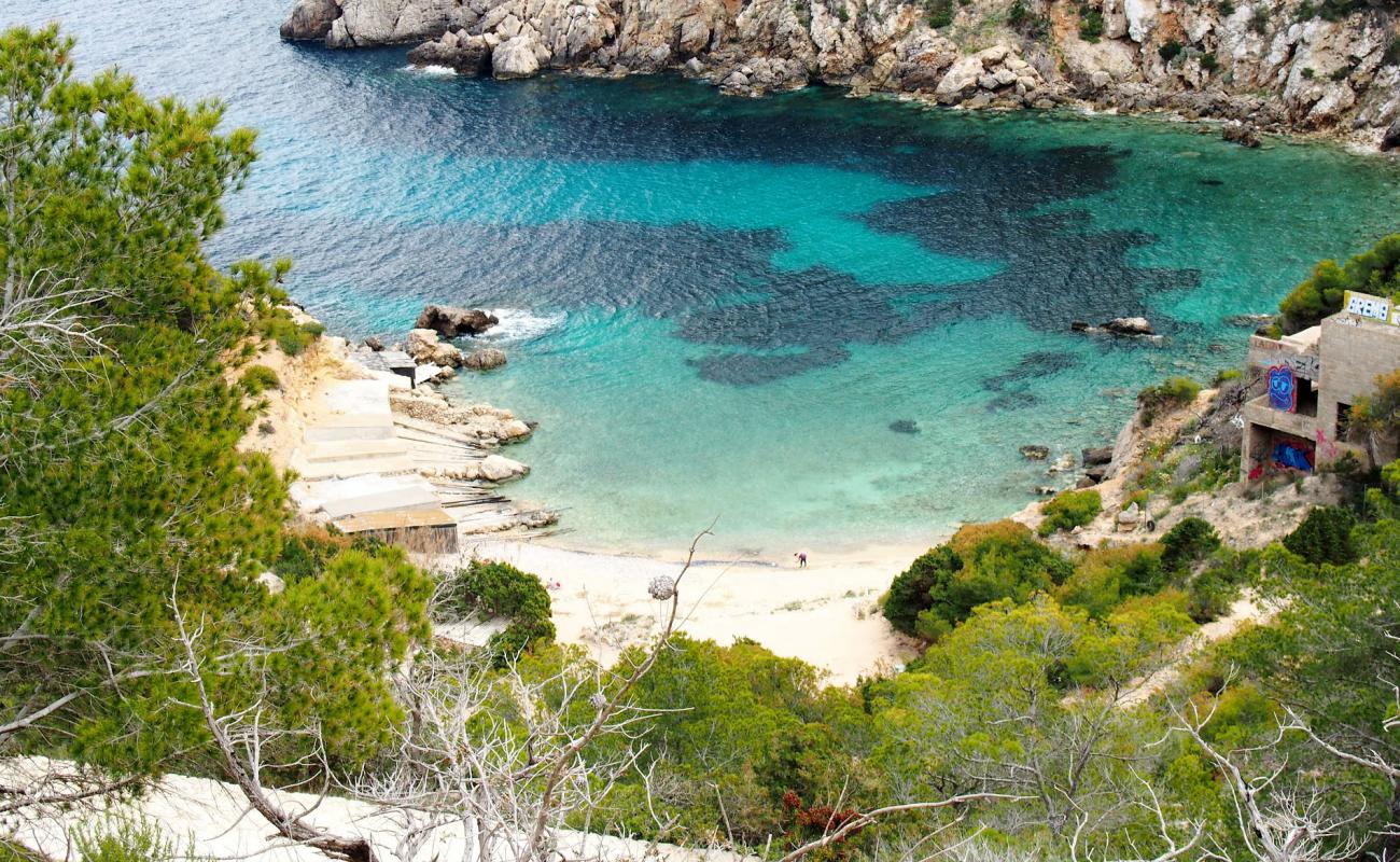 Photo de Cala D'en Serra avec sable brun avec roches de surface