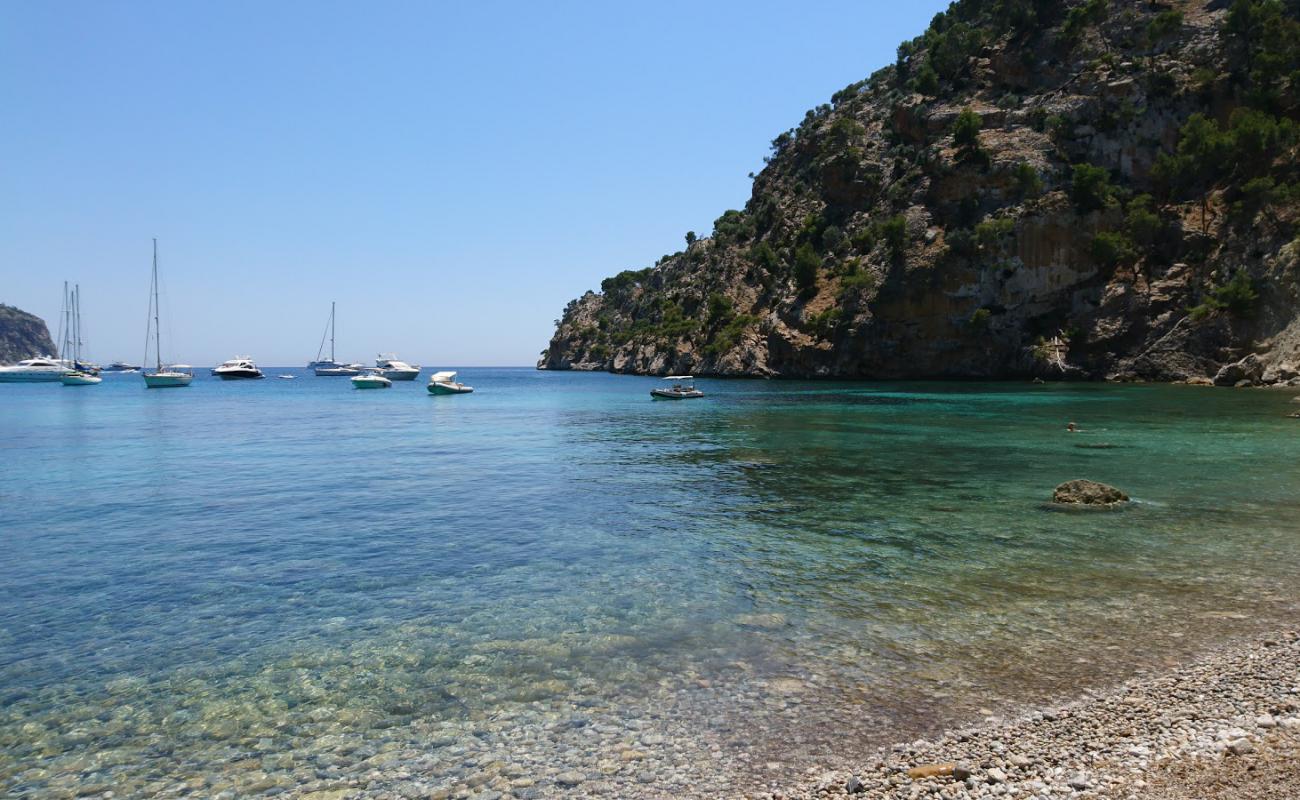 Photo de Cala Blanca avec sable gris avec roches de surface