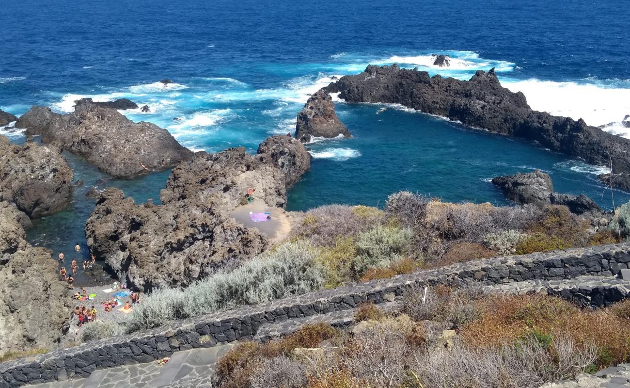 Photo de Charco del Viento avec sable gris & rochers de surface