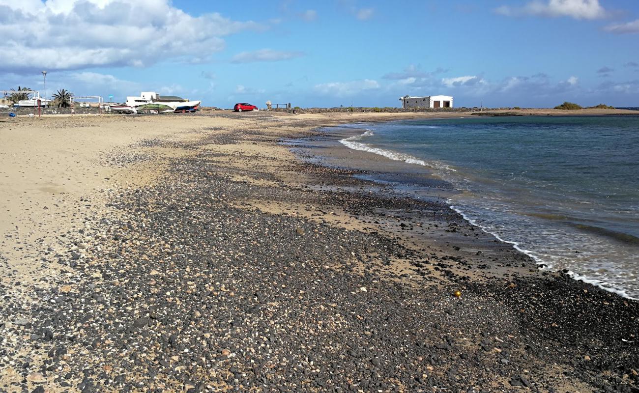 Photo de Playa del Muellito avec sable noir & galets de surface
