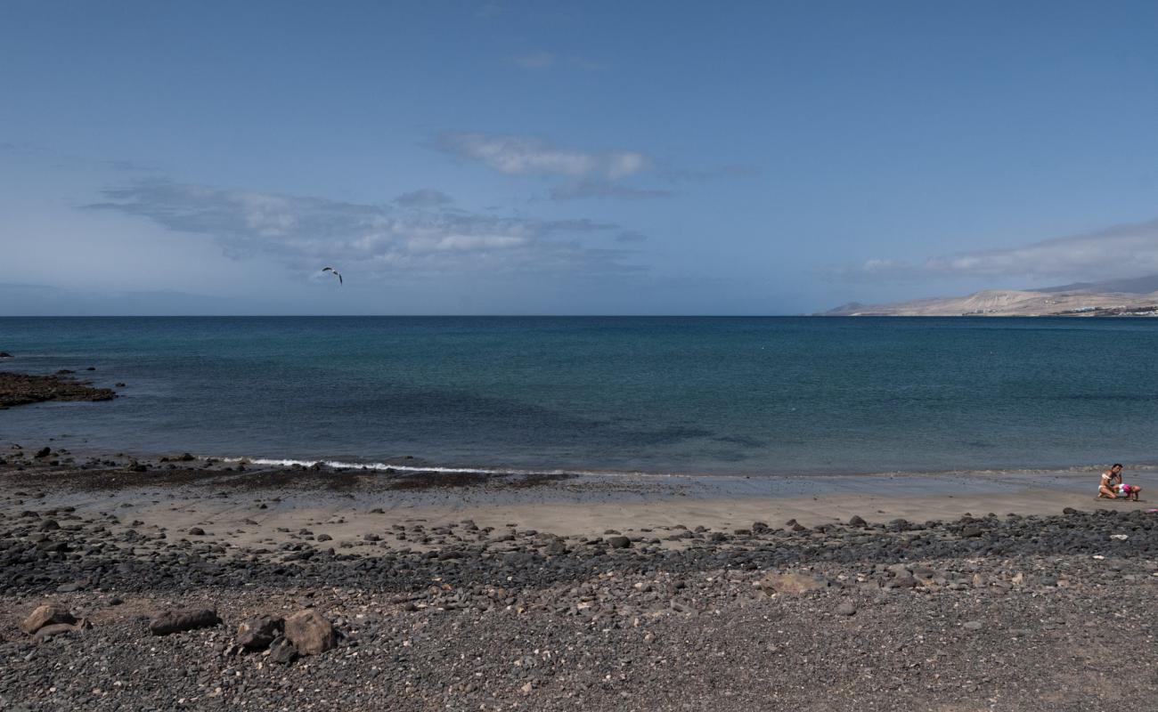 Photo de Playa de la Jaqueta avec sable brun & rochers de surface
