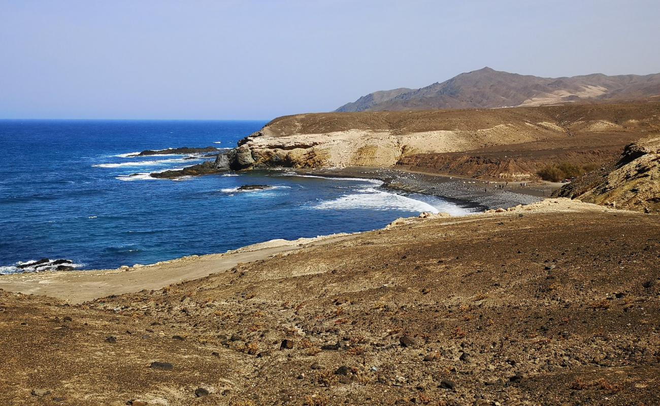 Photo de Playa de Ugan avec sable blanc & rochers de surface