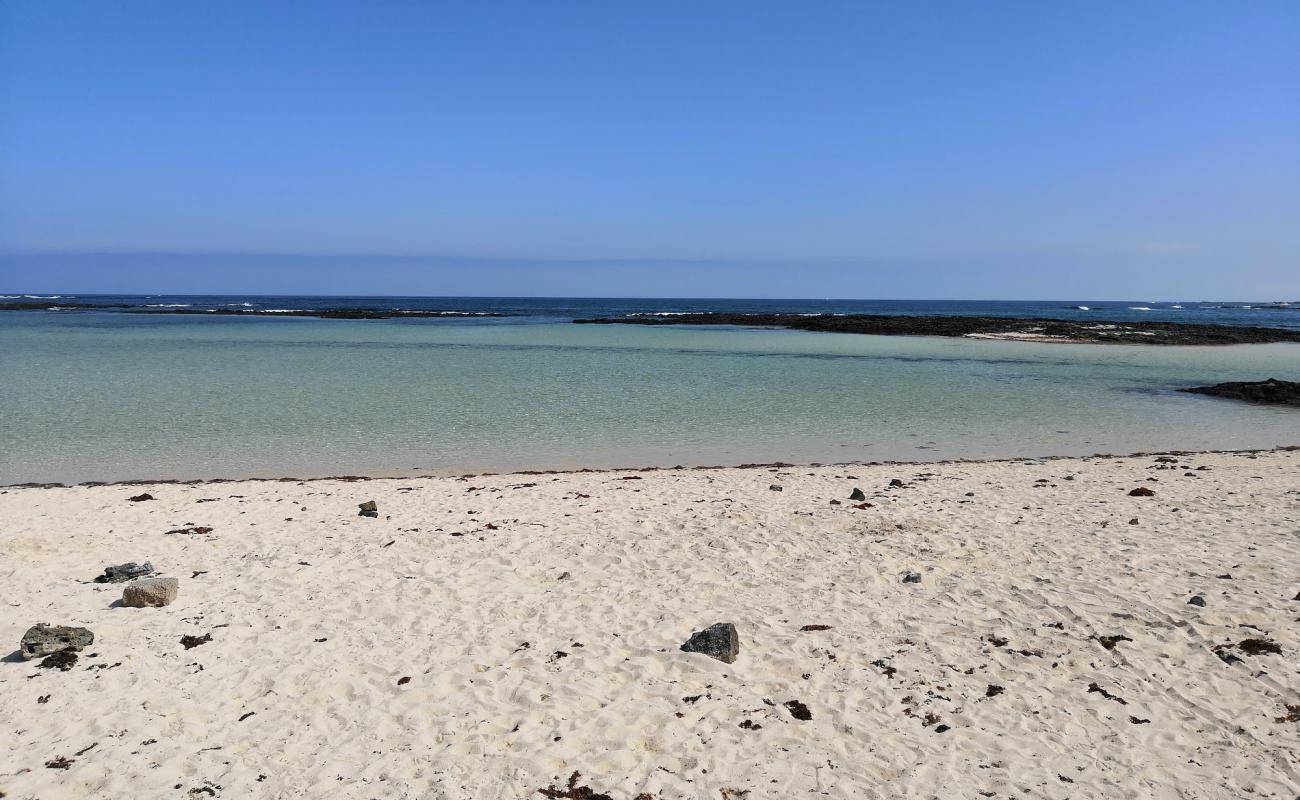 Photo de Playa El Charcon avec sable beige & pierres de surface