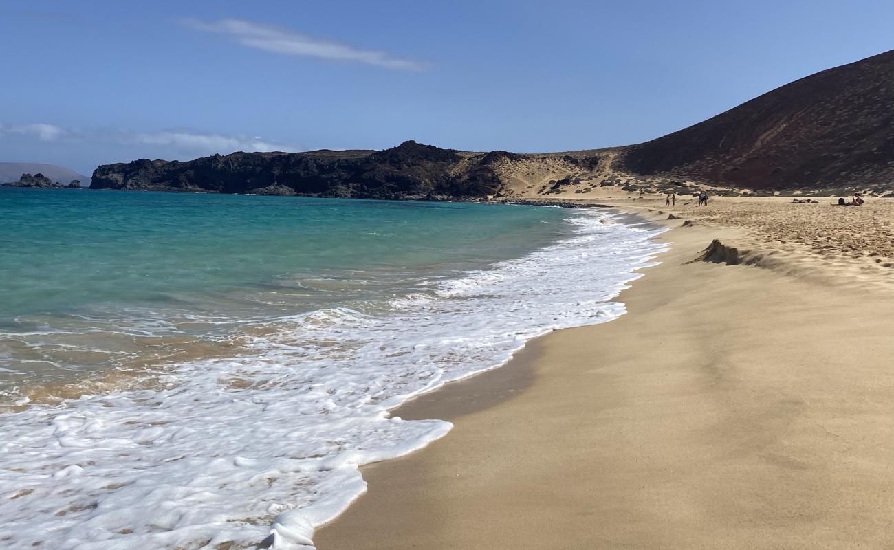 Photo de Playa de las Conchas avec sable fin et lumineux de surface