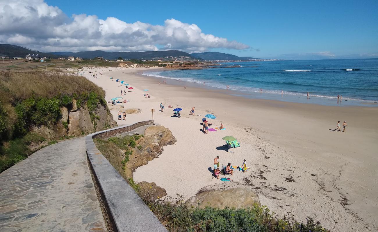 Photo de Llas Beach avec sable beige fin de surface