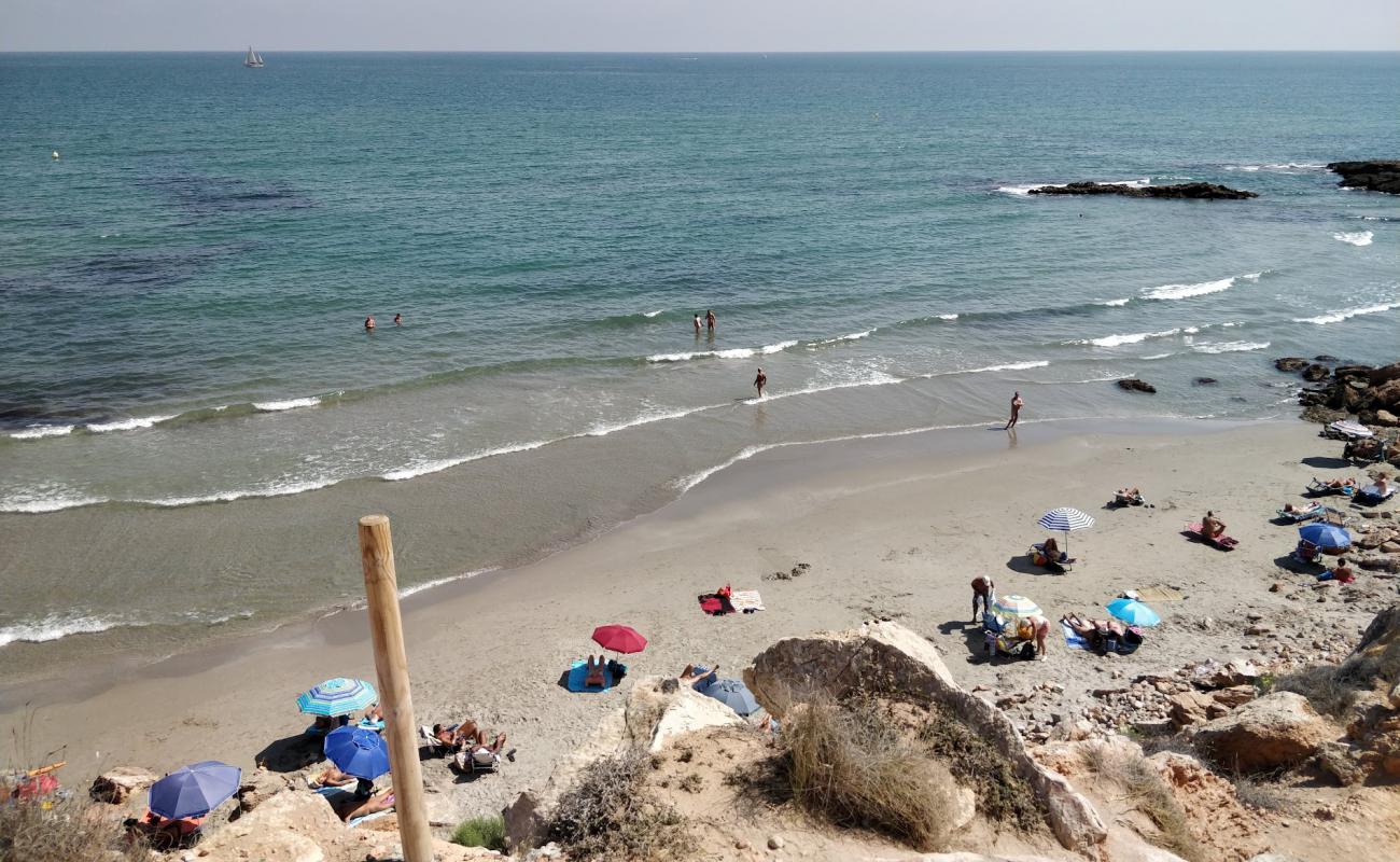 Photo de Playa Flamenca Naturista avec sable brillant et rochers de surface