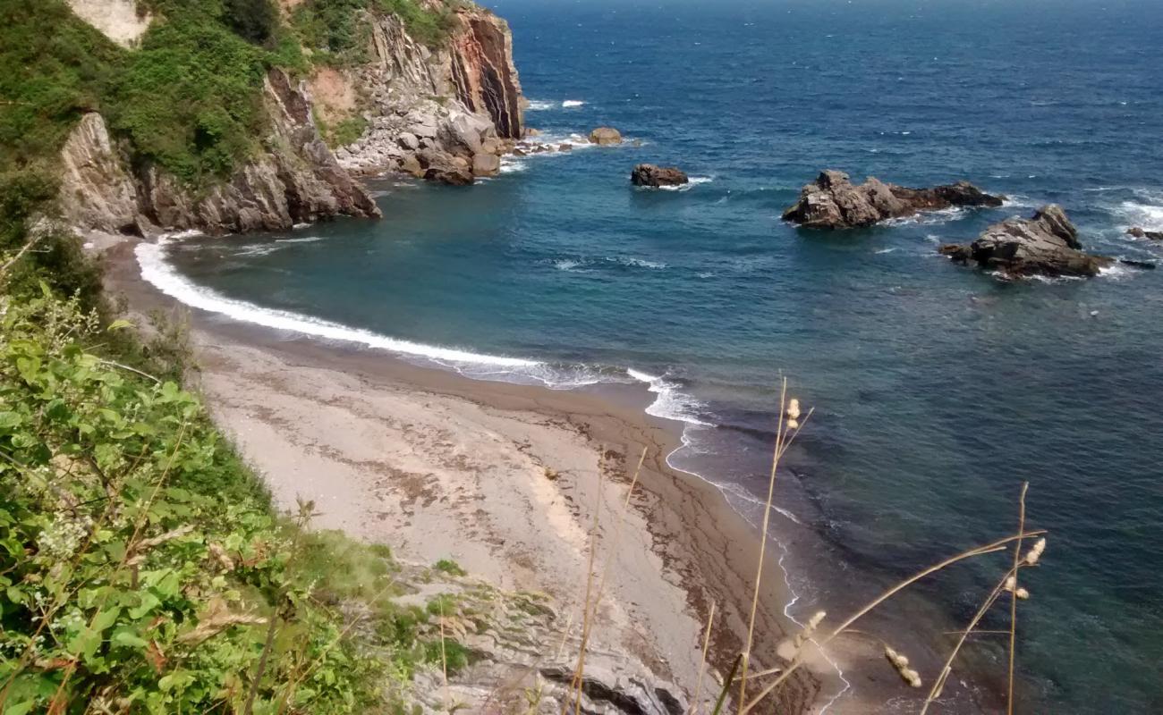 Photo de Playa de Pendueles avec sable gris avec roches de surface