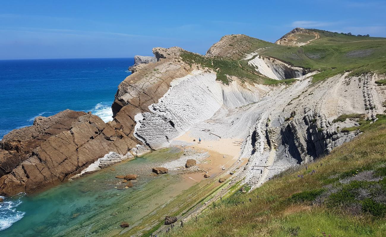 Photo de Playa Pedruquios avec sable beige & pierres de surface