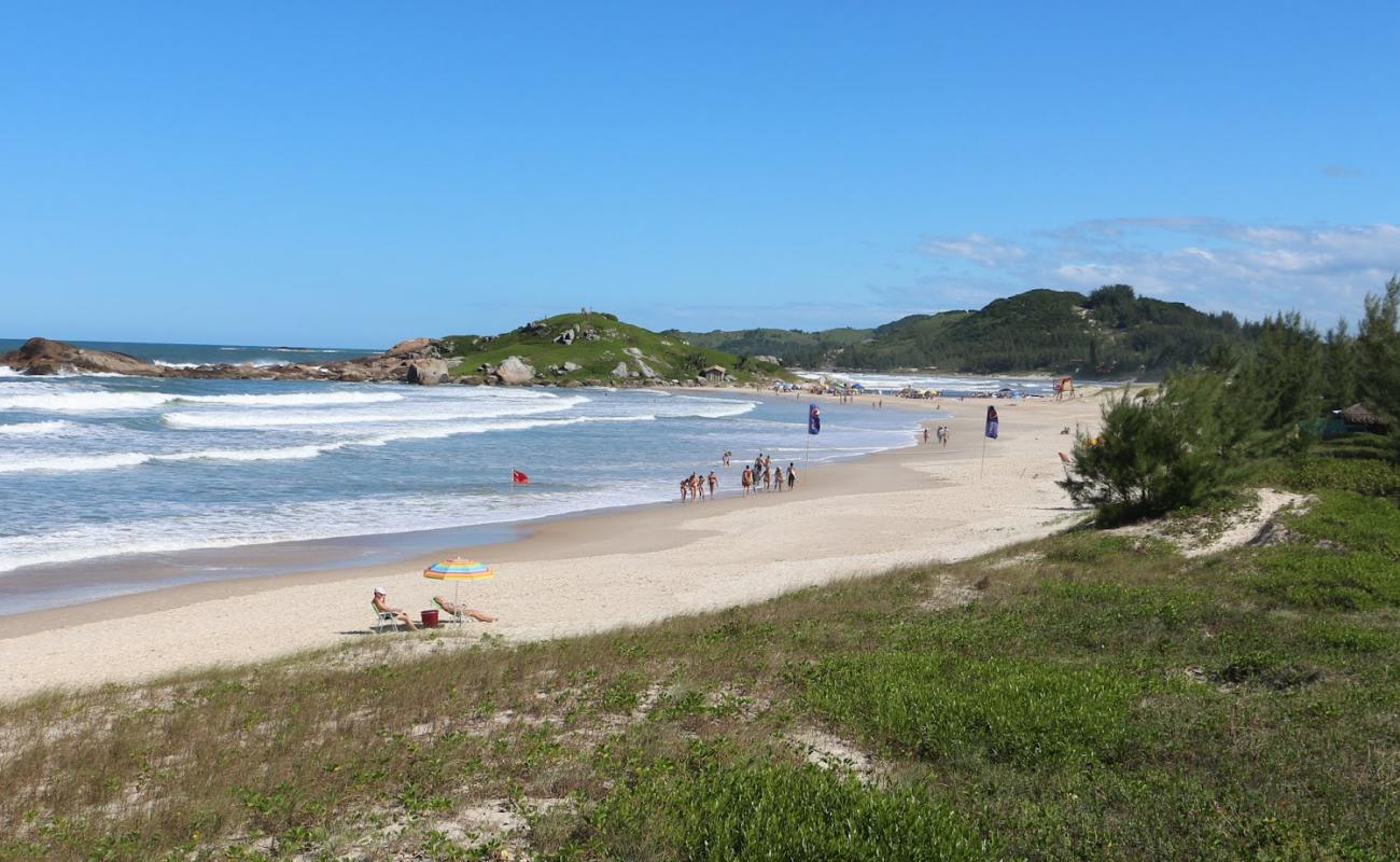 Photo de Praia da Ferrugem avec sable fin et lumineux de surface