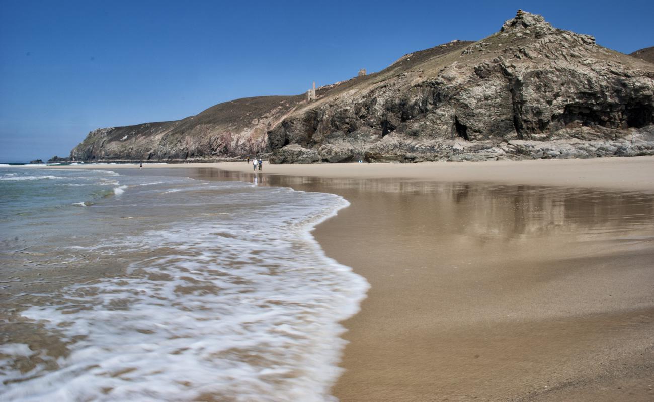 Photo de Chapel Porth beach avec sable brillant et rochers de surface