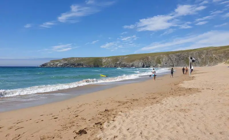 Photo de Holywell Bay avec sable beige de surface
