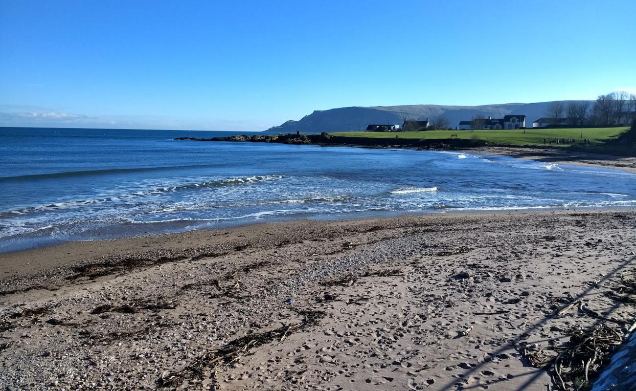 Photo de Cushendall Beach avec sable brun avec roches de surface